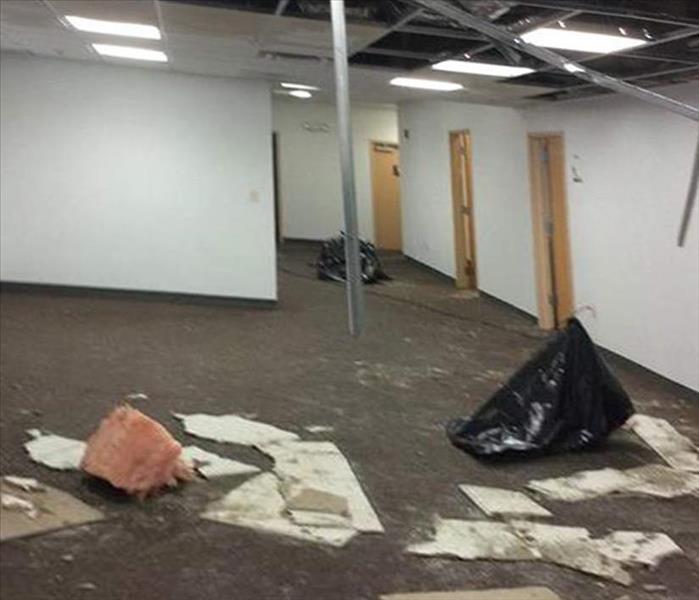 vacant lobby area, fallen ceiling tiles and hanging hardward from the drop-ceiling