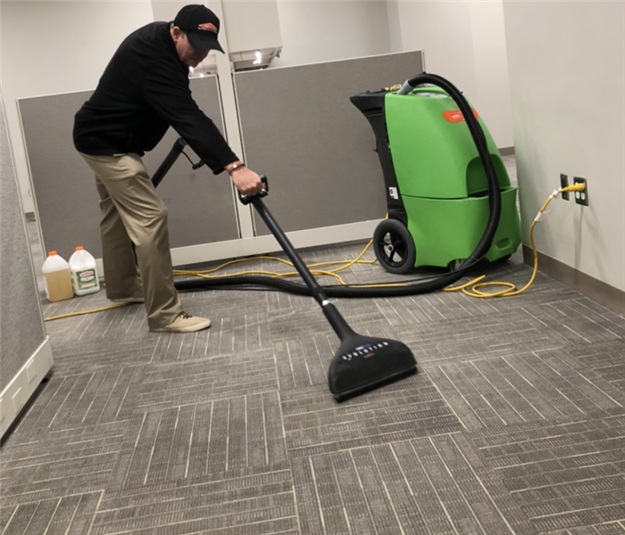 Gary using a portable carpet cleaning machine to clean carpets