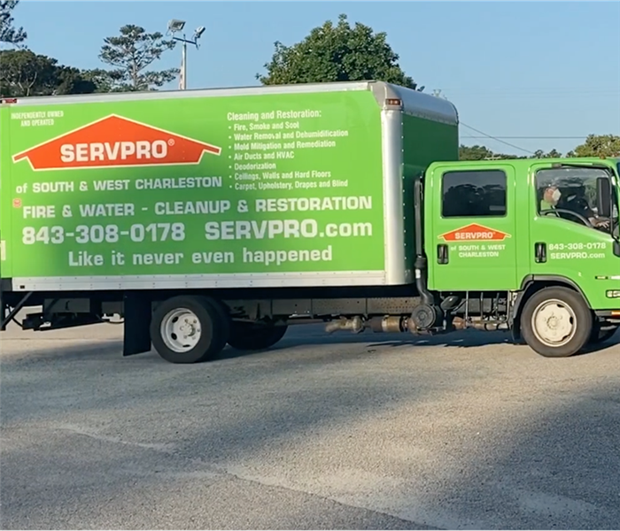 Green SERVPRO truck pulling in to parking lot. 