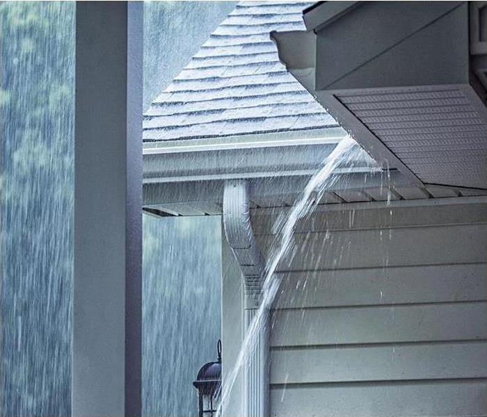 Rain falling on roof and water running down the gutter
